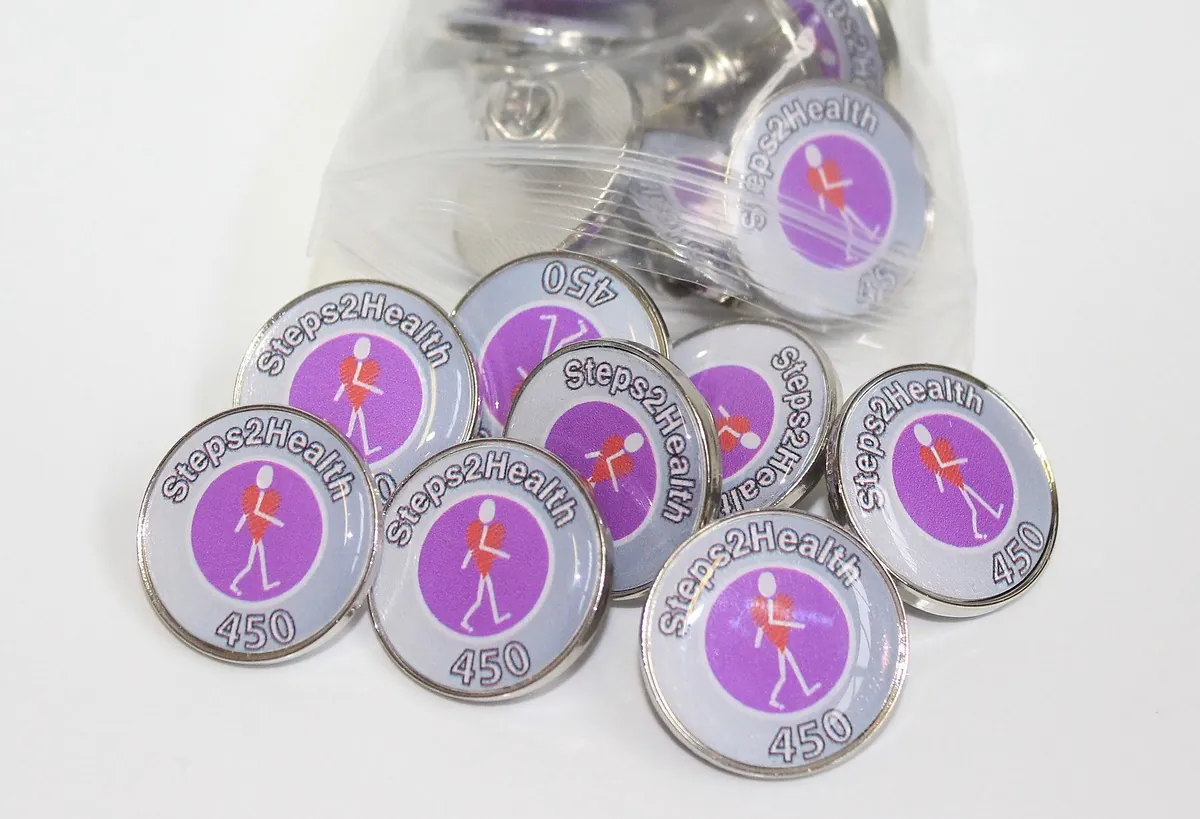 Bag of purple Steps2Health 450 round printed pin badges