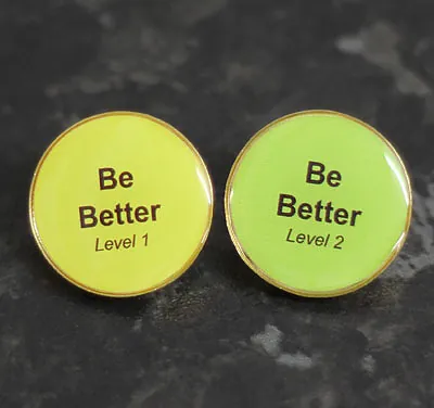 Be Better Level 1 and Level 2 round green pin badges